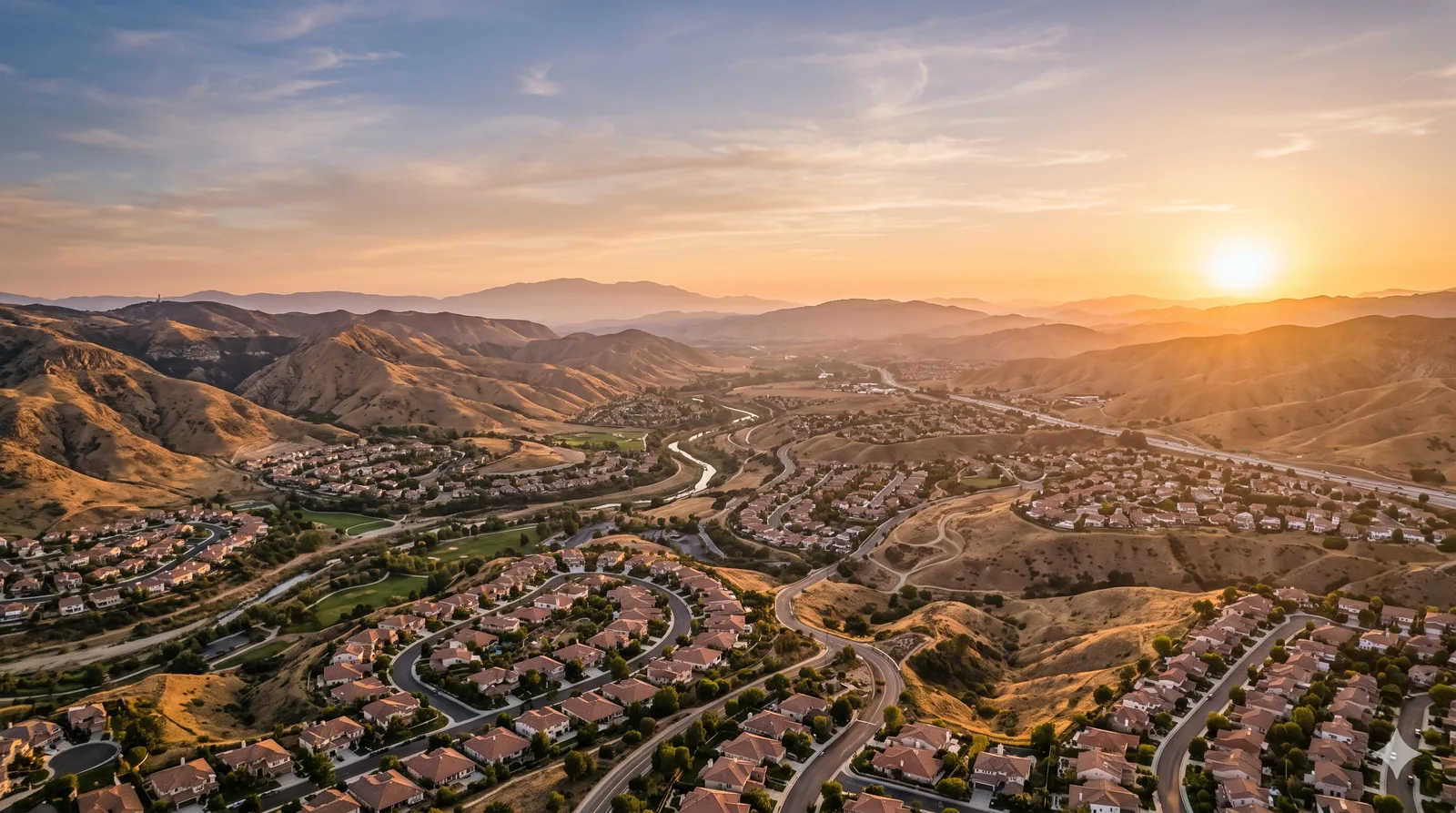 Santa Clarita Valley at golden hour, neighborhoods winding through the hills